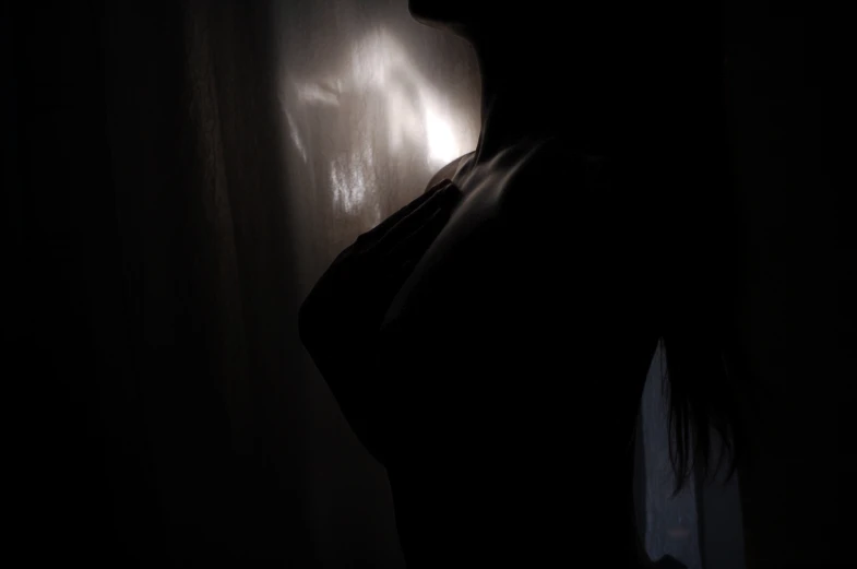 a long haired female posing in the dark