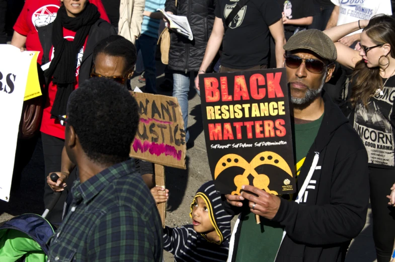 a crowd of people standing around each other holding signs