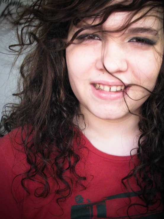 a close - up of a woman with curly hair in her mouth