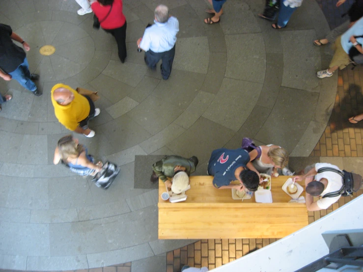 several people are standing outside eating in an outdoor restaurant