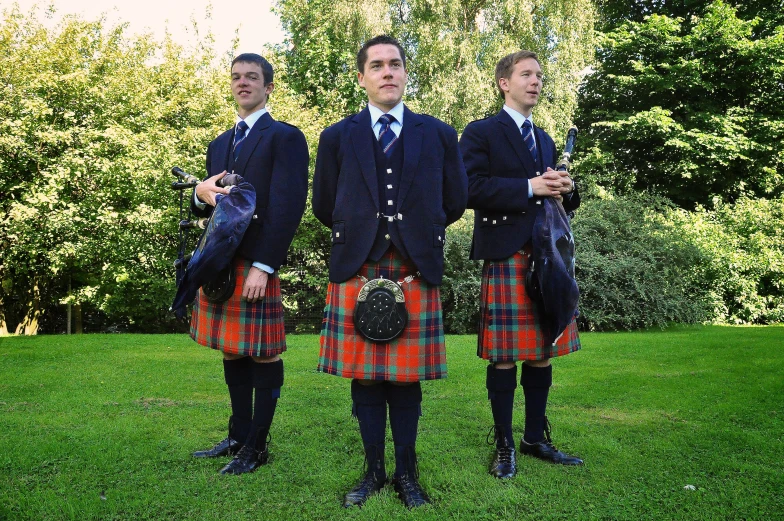 three men in a suit and tartans posing for the camera