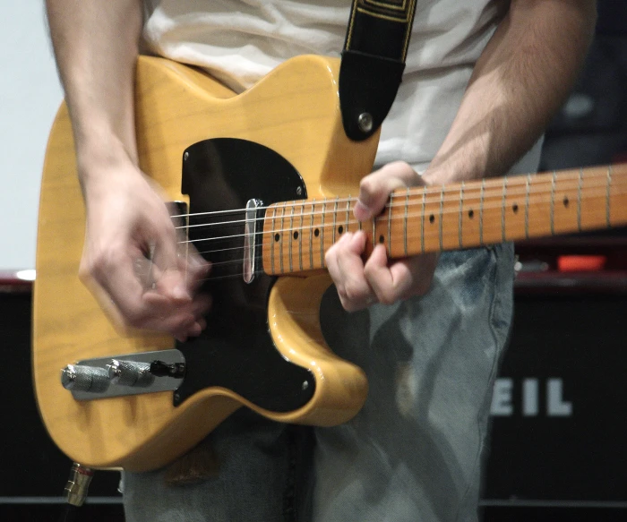 the person is holding the guitar up to play it