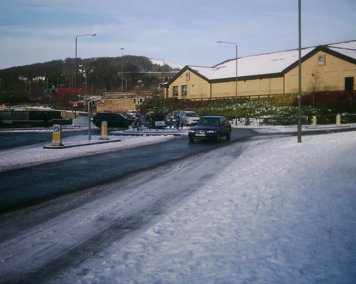 a truck and car moving down the road in the snow