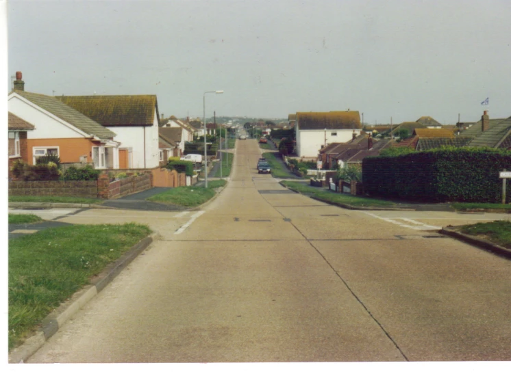 a road surrounded by small houses and green trees