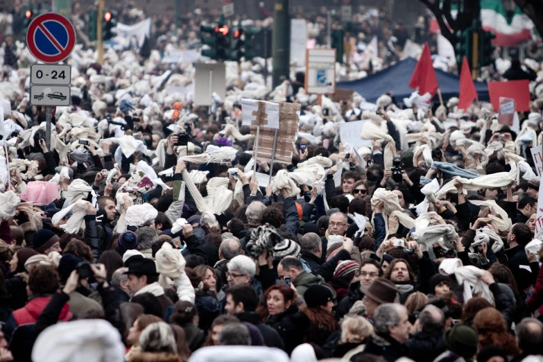 a large group of people in public are holding signs