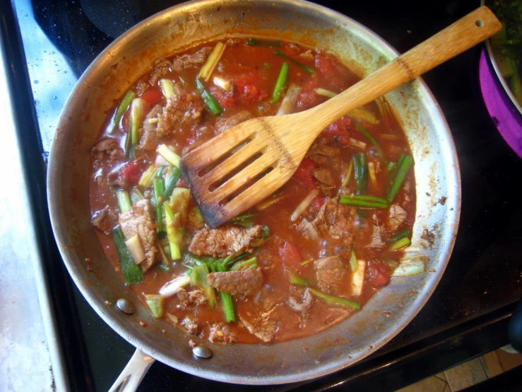 a wooden spoon in a pot of stew