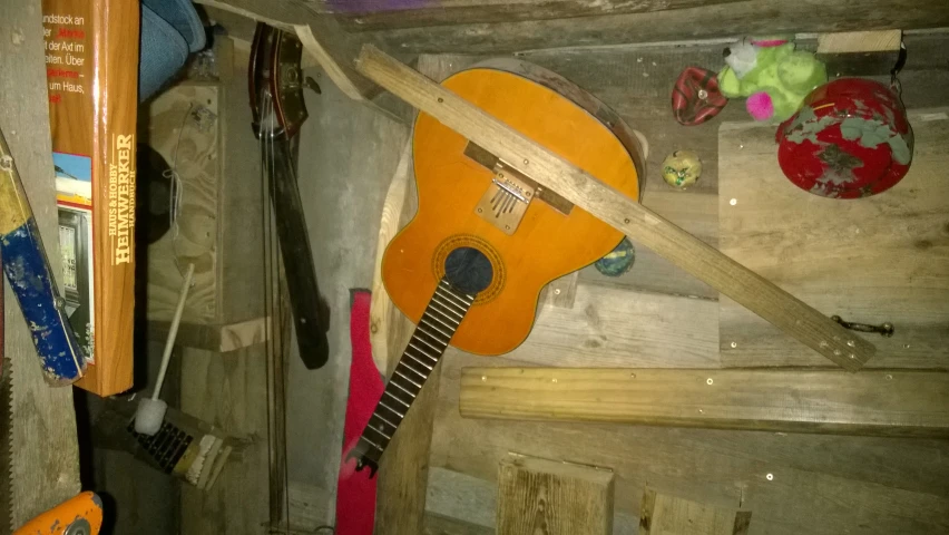 a guitar hanging on a wood wall