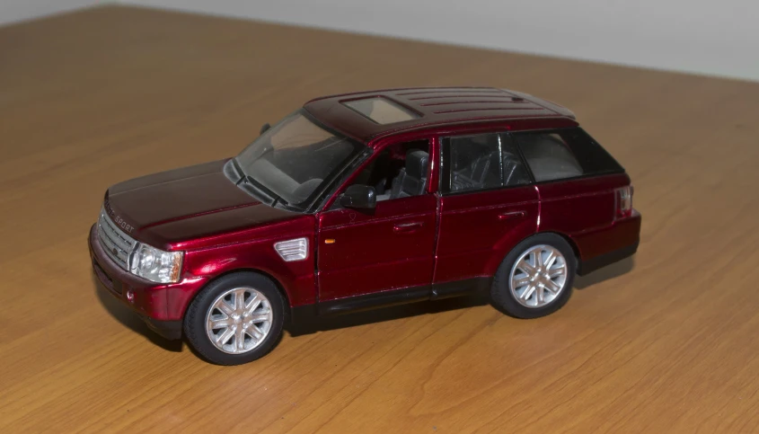 a mini - suv on a wooden surface with one door open