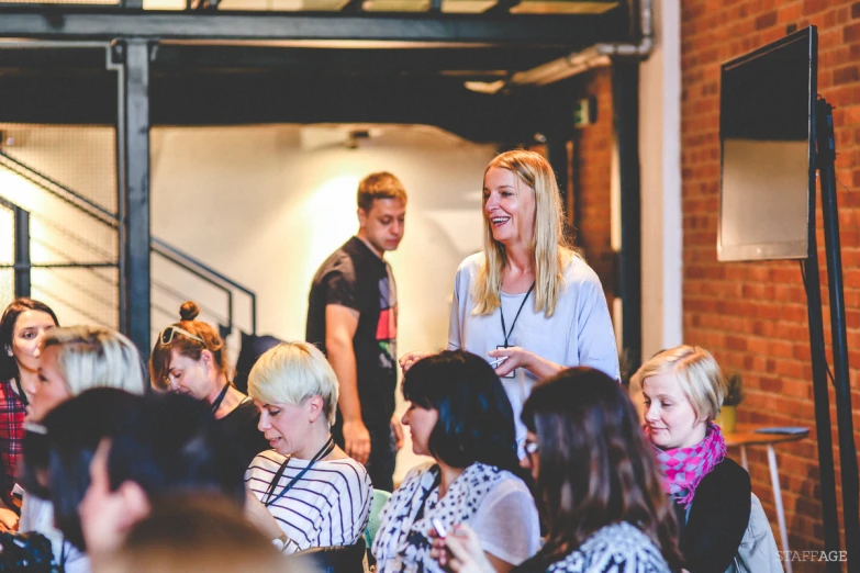 people sitting in chairs in a room with a brick wall