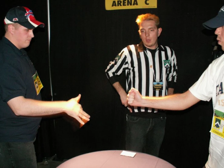 two men wearing referee's attire are talking to each other