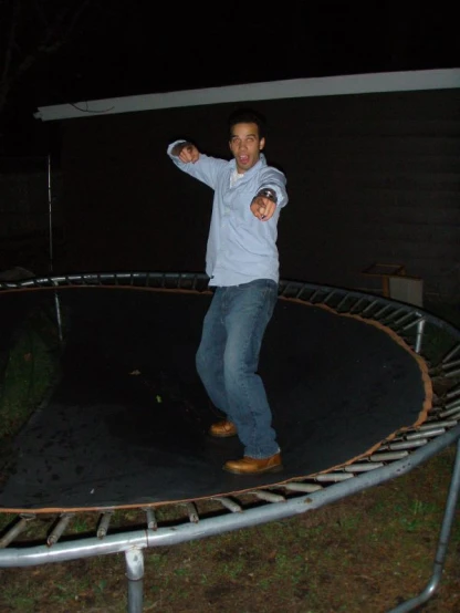 a man is standing on a trampoline outside