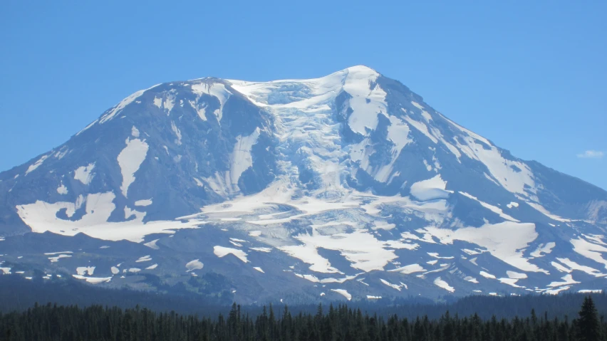 a snowy mountain rises high on a clear day