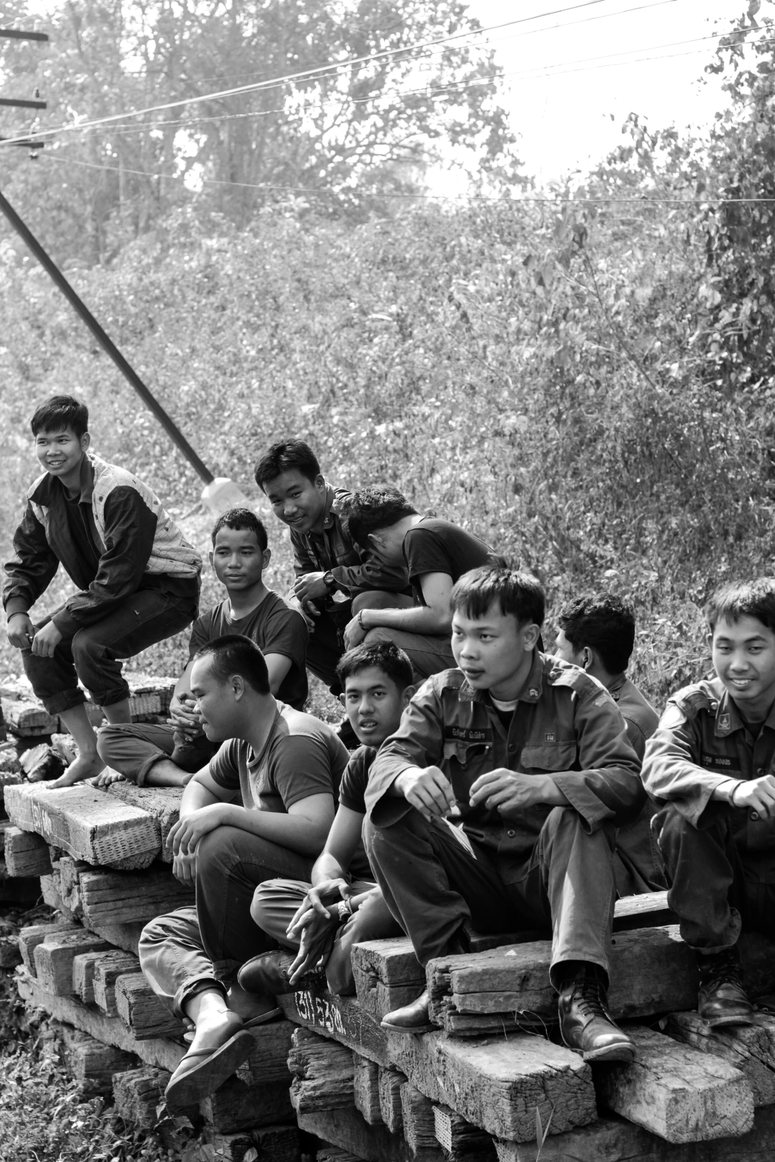 black and white po of young men sitting on bricks