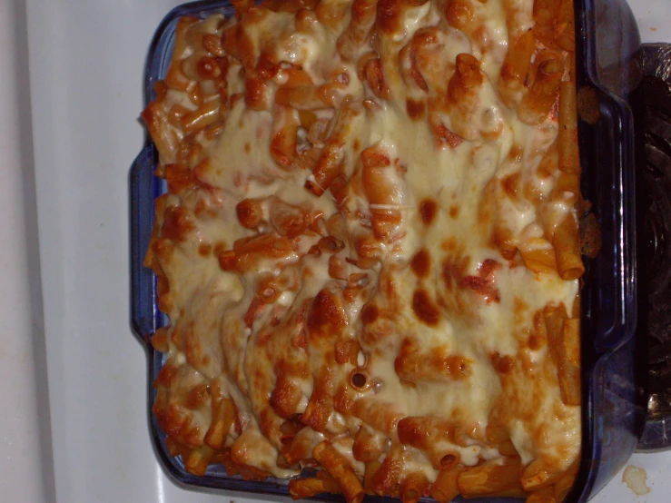 a casserole covered in cheese sitting on a stove top