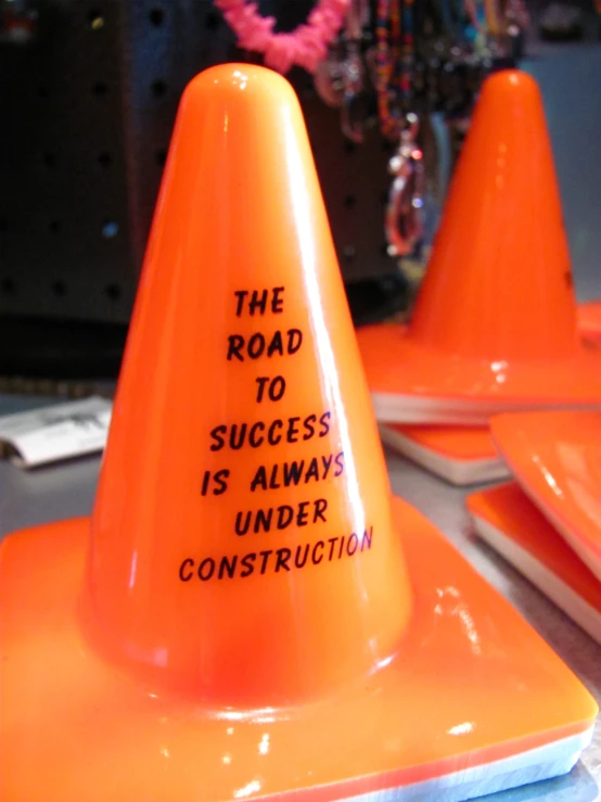 two orange traffic cones with writing on them