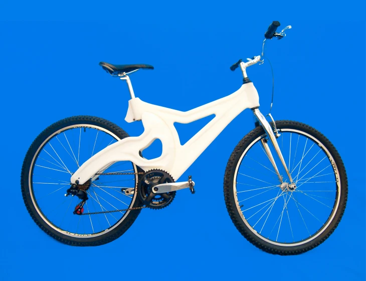 a white bicycle with white rims against a blue sky