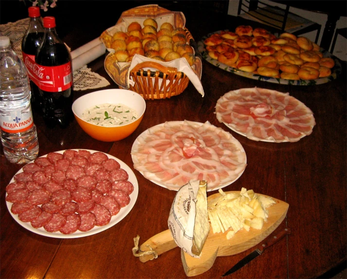 food spread out on a wooden table with apples, ham, potatoes and ham