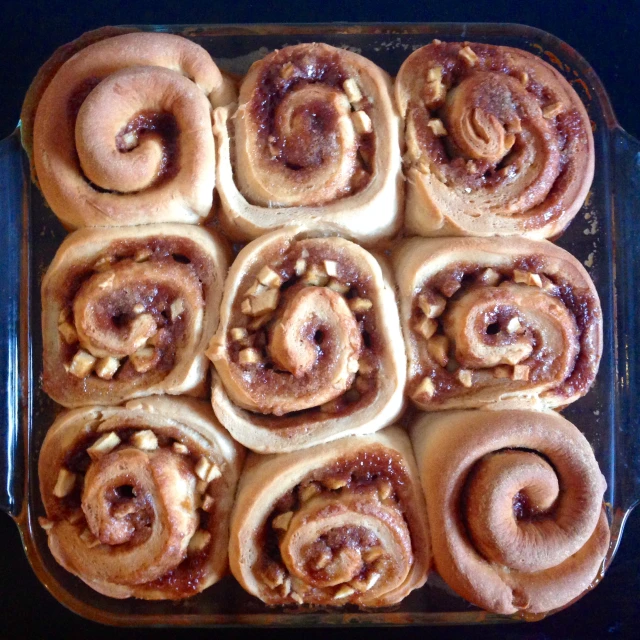 a pan filled with cinnamon buns topped with walnuts