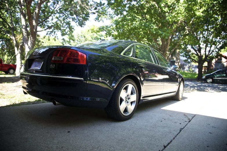 a black car with chrome rims parked on the street