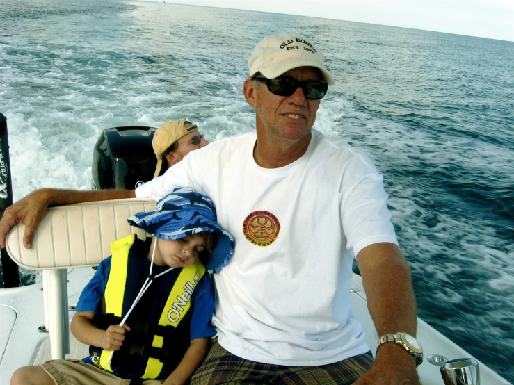 a man sitting next to a boy on top of a boat