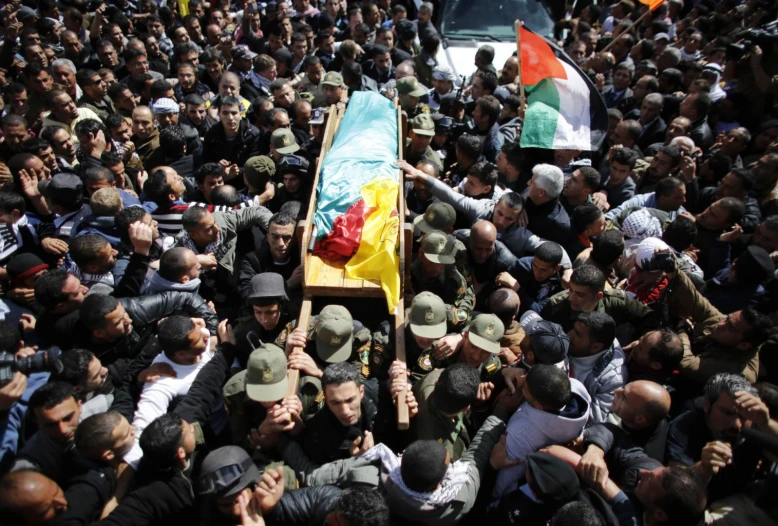 a large crowd surrounding a casket holding a dead man