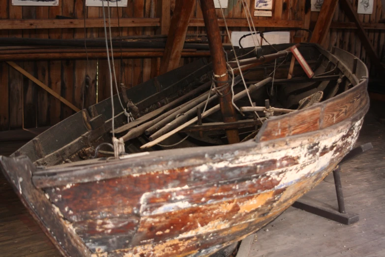a boat in a building with lots of wood on display