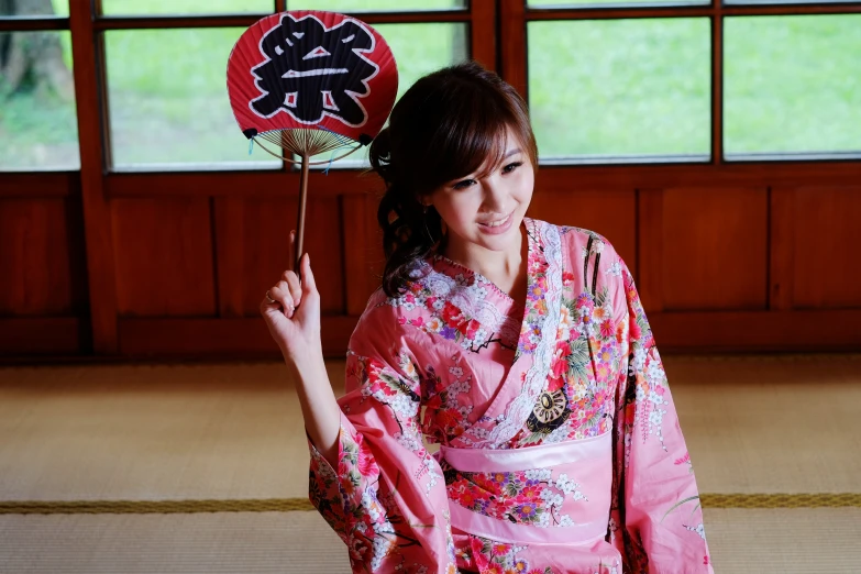 a woman is wearing a kimono and holding a fan in her hand
