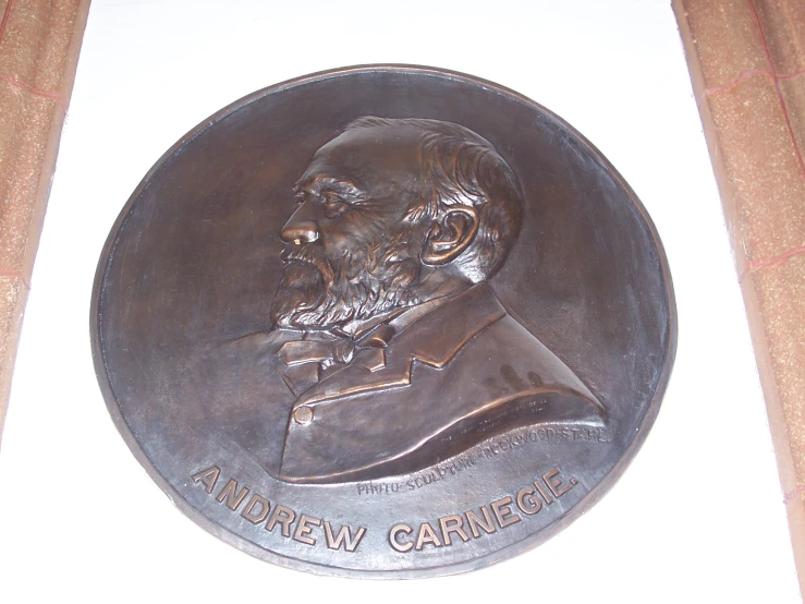 a large, bronze medal with the portrait of a man