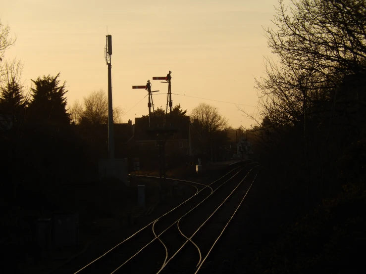 a light pole with a street lamp next to train tracks