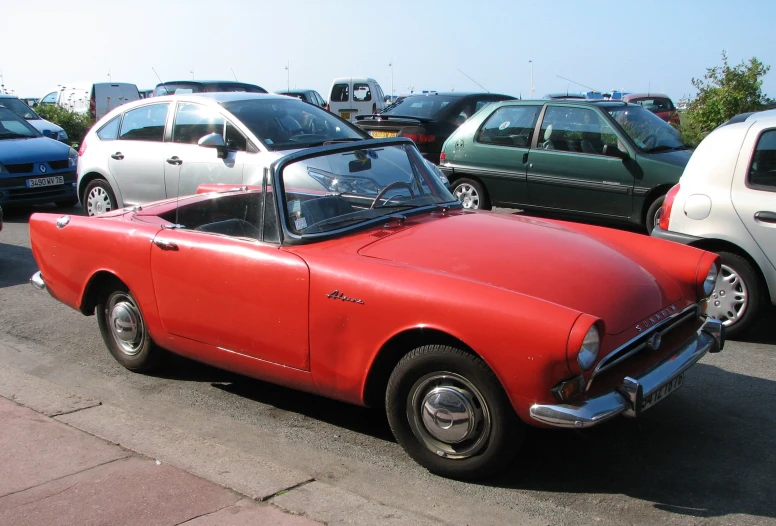 a red old time car with its hood open