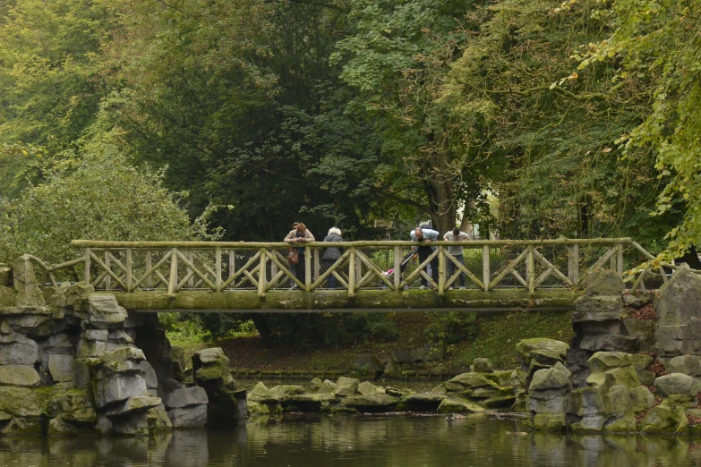 people standing on a bridge over the water