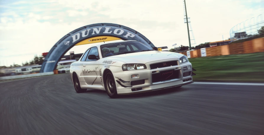 a white vehicle driving by the run line in a race