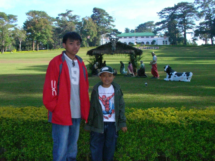 a man standing next to a child in a field