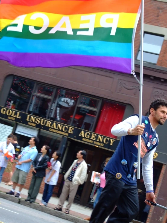 a man holding a flag with a group of people walking behind him