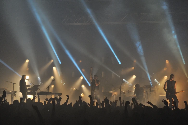 a group of people playing guitars in front of several other groups of lights