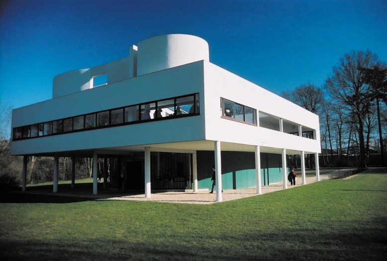 a large white building sitting on top of a grass covered field