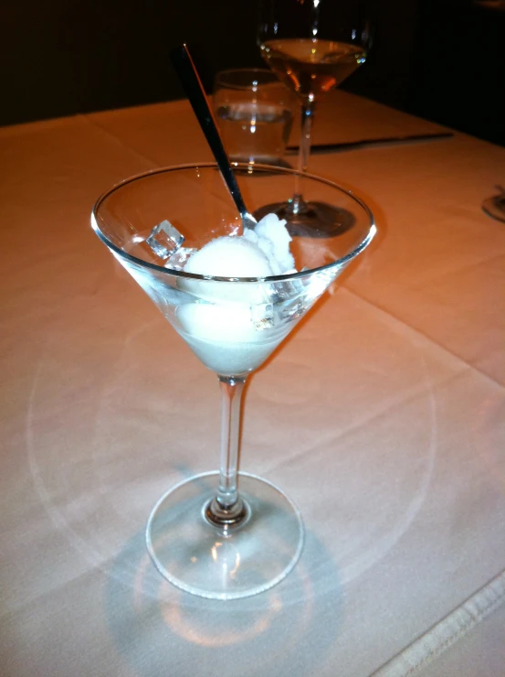 a martini is on a table with two glasses of drinks