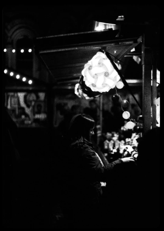 people standing and looking at a lit up umbrella