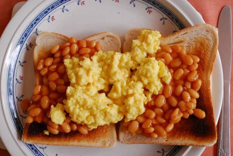 a plate of baked beans and eggs on toast