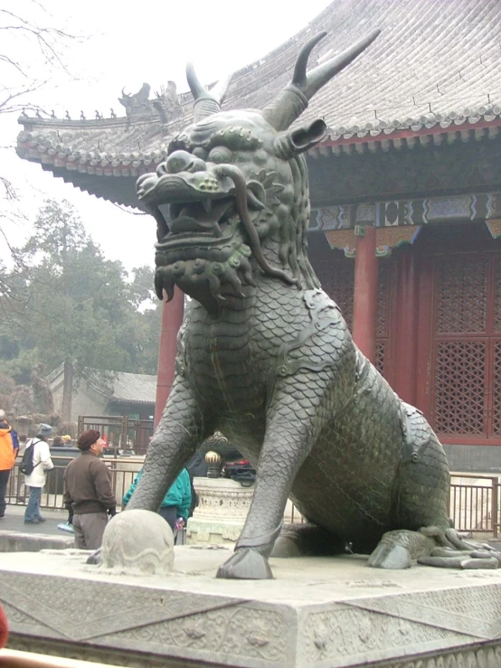 a statue of a dragon near the chinese buildings