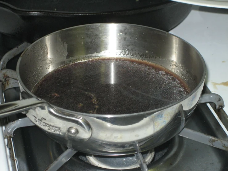 a pan filled with a liquid sits on top of an oven