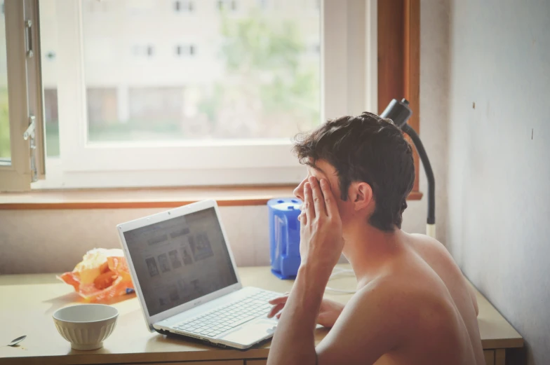 a man sitting in front of a laptop computer