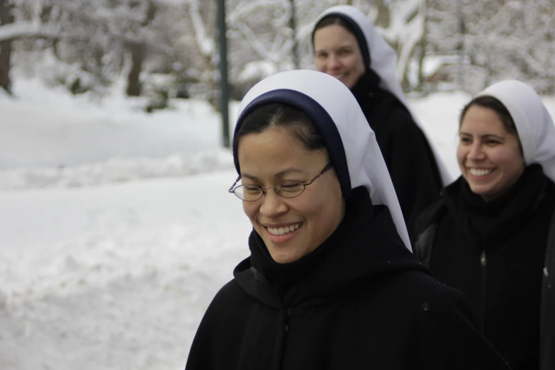 two women in black are wearing black and white headscarves