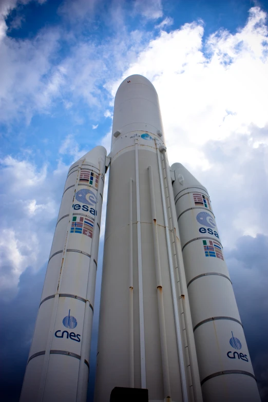 two saturn rockets sitting side by side in the cloudy sky