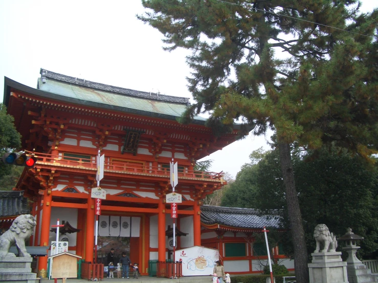 the chinese building in front of a big tree