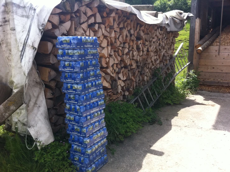 several stacks of firewood lined up along side a building