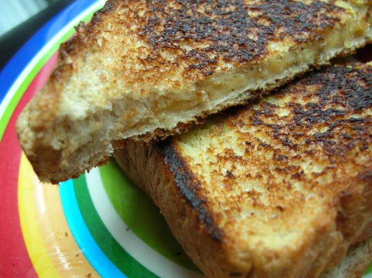 two grilled sandwiches on a plate with a fork