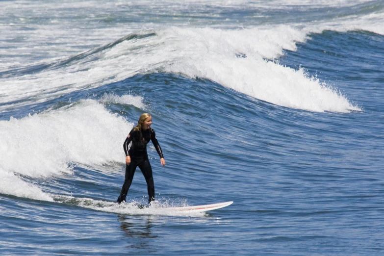 a person wearing a black wetsuit surfing in the ocean