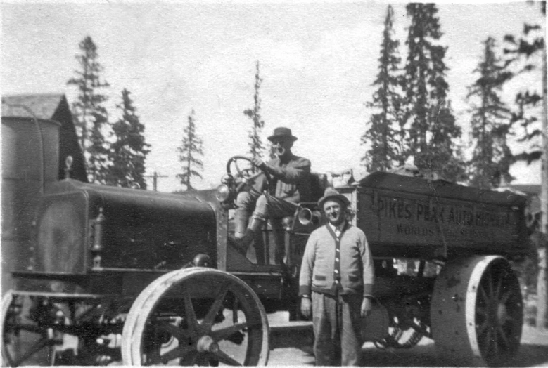 three men standing in front of a steam engine