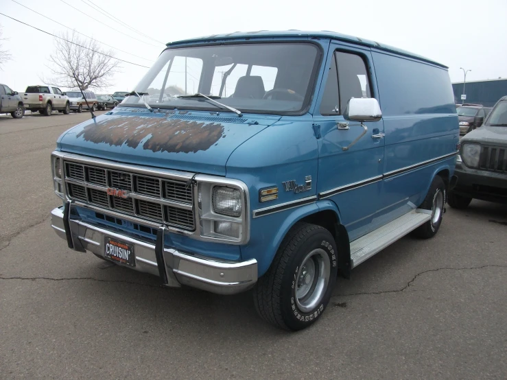 an old blue van is parked in the parking lot